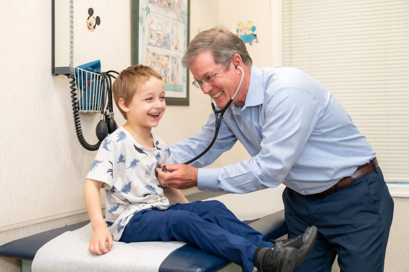 Doctor taking boy patient heart rate
