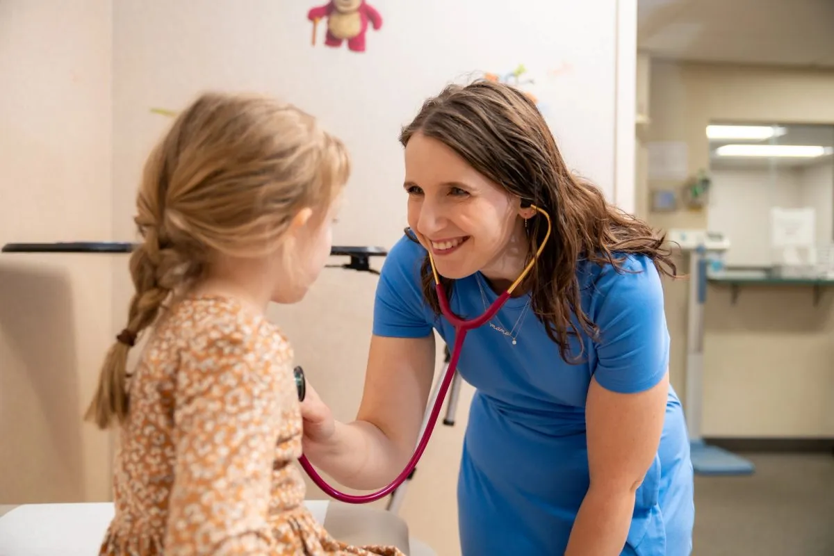 Nurse taking Girl patient heart rate